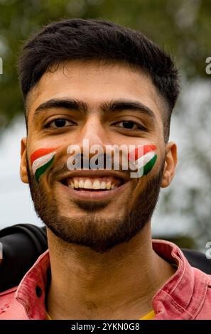 Primo piano di un giovane allegro con la bandiera dell'india dipinta sul viso Foto Stock