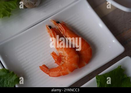 Gamberi bolliti placcati su un piatto bianco Foto Stock