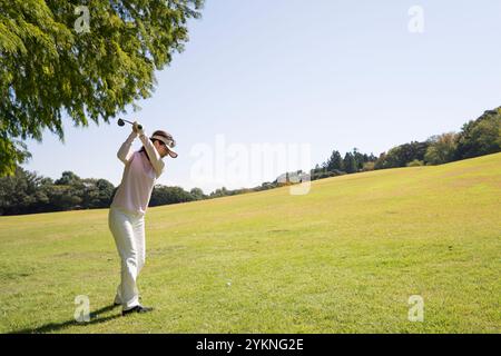 Donna di mezza età che gioca a golf Foto Stock