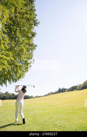 Donna di mezza età che gioca a golf Foto Stock