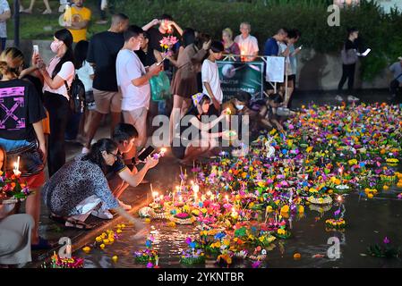 Persone che lanciano i loro cesti decorati sul lago nel Parco di Benjasiri, la notte della luna piena durante il festival Loy Krathong Foto Stock