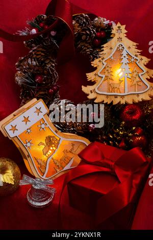 Albero di Natale con luci calze, scatole regalo, campane, ghirlande e ornamenti Foto Stock