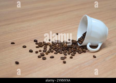 Tazza di caffè rovesciata con chicchi di caffè Foto Stock