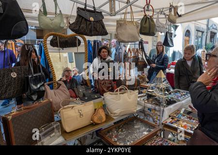 Arezzo, Italia - 2 novembre 2024: I visitatori curiosano tra i pezzi d'antiquariato del mercato mensile del centro storico di Arezzo, esplorando gli oggetti esposti dai venditori lungo le strade e le piazze Foto Stock