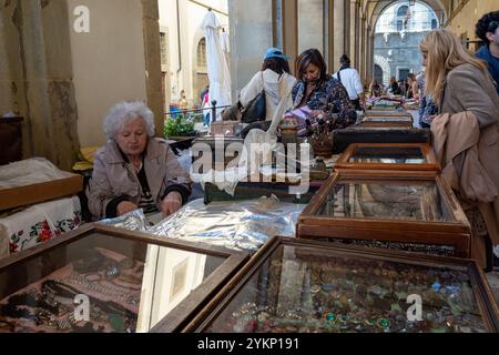 Arezzo, Italia - 2 novembre 2024: I venditori espongono oggetti retrò e antichi al mercato mensile del centro storico di Arezzo, con oggetti da collezione, mobili e gioielli. Foto Stock