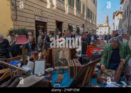 Arezzo, Italia - 2 novembre 2024: I visitatori curiosano tra i pezzi d'antiquariato del mercato mensile del centro storico di Arezzo, esplorando gli oggetti esposti dai venditori lungo le strade e le piazze Foto Stock