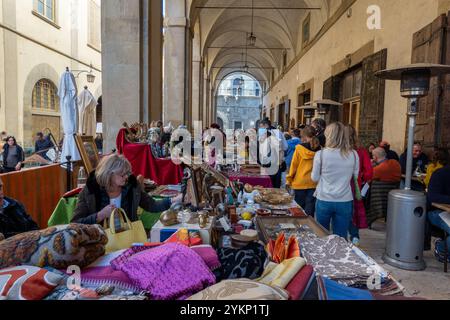 Arezzo, Italia - 2 novembre 2024: I visitatori curiosano tra i pezzi d'antiquariato del mercato mensile del centro storico di Arezzo, esplorando gli oggetti esposti dai venditori lungo le strade e le piazze Foto Stock