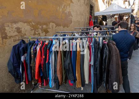 Arezzo, Italia - 2 novembre 2024: I visitatori curiosano tra i pezzi d'antiquariato del mercato mensile del centro storico di Arezzo, esplorando gli oggetti esposti dai venditori lungo le strade e le piazze Foto Stock