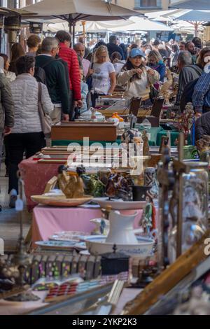 Arezzo, Italia - 2 novembre 2024: I visitatori curiosano tra i pezzi d'antiquariato del mercato mensile del centro storico di Arezzo, esplorando gli oggetti esposti dai venditori lungo le strade e le piazze Foto Stock