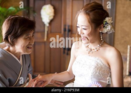 Nonna e sposa sorridono e si tengono le mani in gioia a una cerimonia nuziale Foto Stock