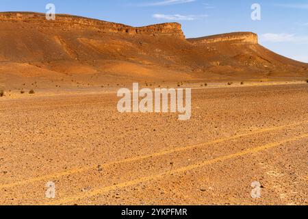 Deserto di pietra secca e montagna solitaria sullo sfondo. Marocco Foto Stock