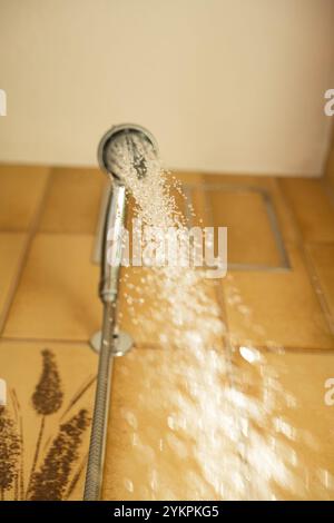 Soffione doccia con acqua corrente. Acquisizione ad alta velocità dell'otturatore del flusso d'acqua, gocce d'acqua, profondità di campo ridotta, angolazione ridotta, assenza di persone, doccia domestica, Foto Stock