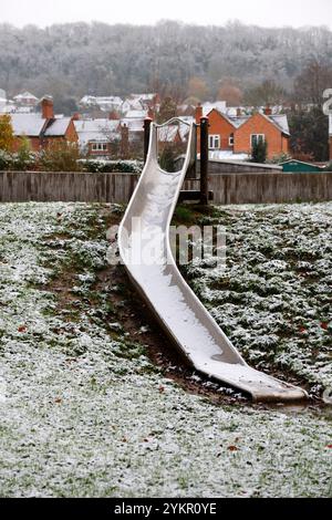 Neve su uno scivolo per bambini in un parco innevato. Viste intorno a Ledbury, Herefordshire, Inghilterra, in una giornata invernale innevata. - 19 novembre 2024 foto di Foto Stock