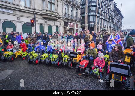 Londra, Regno Unito. 19 novembre 2024 i bambini viaggiano su trattori giocattolo in Parliament Square durante una manifestazione degli agricoltori mentre migliaia di agricoltori sono scesi a Whitehall per protestare contro i cambiamenti alla tassa di successione annunciati dal cancelliere Rachel Reeves nel bilancio del mese scorso. Gli agricoltori affermano che sarà sempre più difficile passare le aziende attraverso generazioni a causa di costi fiscali aggiuntivi. Credito. Amer Ghazzal/Alamy Live News Foto Stock