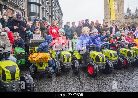 Londra, Regno Unito. 19 novembre 2024 i bambini viaggiano su trattori giocattolo in Parliament Square durante una manifestazione degli agricoltori mentre migliaia di agricoltori sono scesi a Whitehall per protestare contro i cambiamenti alla tassa di successione annunciati dal cancelliere Rachel Reeves nel bilancio del mese scorso. Gli agricoltori affermano che sarà sempre più difficile passare le aziende attraverso generazioni a causa di costi fiscali aggiuntivi. Credito. Amer Ghazzal/Alamy Live News Foto Stock