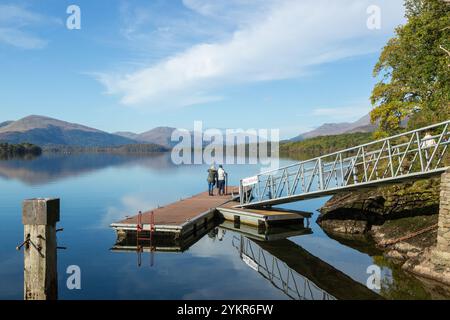 Gente su un pontone sul lago Lomond a Balmaha, Stirling, Scozia Foto Stock