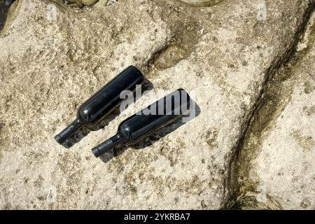 Due bottiglie di vino sulla costa rocciosa del Mar Caspio. Foto Stock