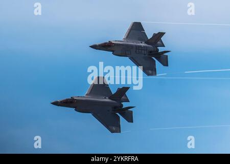 Jones Beach, New York, USA - 29 maggio 2022: Due eleganti e grigi caccia F-35 Lightning II volano attraverso un cielo blu in formazione durante uno spettacolo aereo. Il Foto Stock