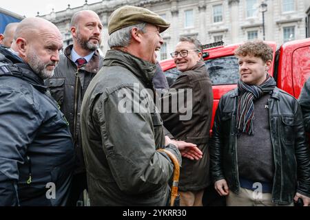 Londra, Regno Unito. 19 novembre 2024. Nigel Farage, leader del Partito Riformista, all'evento. Un numeroso gruppo di bambini allevatori su trattori giocattolo conduce la strada per una processione intorno a Parliament Square. Gli agricoltori, le loro famiglie e i sostenitori protestano nel centro di Londra contro i piani di introdurre una tassa di successione per gli agricoltori. Crediti: Imageplotter/Alamy Live News Foto Stock