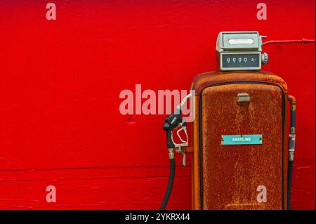 Vecchia pompa di alimentazione di fronte al muro di cemento rosso sull'isola di Japonski, Sitka, Alaska, Stati Uniti. Foto Stock