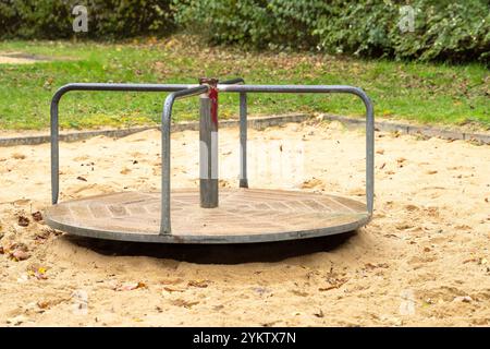 Augusta, Baviera, Germania - 18 novembre 2024: Attrezzatura da gioco abbandonata dai bambini in un parco giochi. Detto carosello, twister e ponte girevole, simbolo di giocattoli difettosi e vecchi nelle aree pubbliche. *** Von Kindern verlassenes Spielgerät, auf einem Spielplatz. Karussel, Twister und Drehbrücke genannt, Symbol für defekte und altes Spielzeug im öffentlichen Bereich. Foto Stock