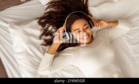 Soddisfatta giovane afroamericana che ascolta la musica Foto Stock