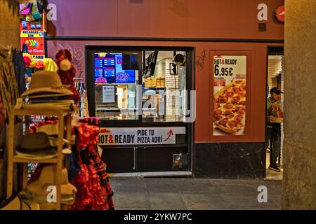 Madrid, Spagna, centro storico, 04-07-2024: Una pizzeria con un cartello luminoso che dice "Hot & Ready" in una strada trafficata. Il negozio dispone di un menu a tavola vi Foto Stock