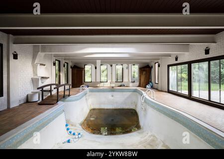 Una piscina interna vuota all'interno di una villa. Questa casa è stata demolita da allora. Foto Stock