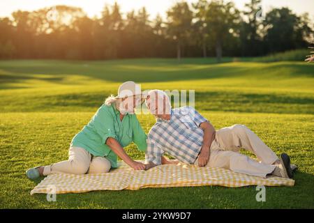 Una coppia di anziani sdraiata su una coperta. Un uomo e una donna sorridenti. Annegando negli occhi. Non sognavo una felicità più grande Foto Stock