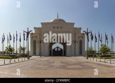 Un'immagine della più lontana porta di Qasr al Watan affiancata da numerose bandiere degli Emirati Arabi Uniti Foto Stock