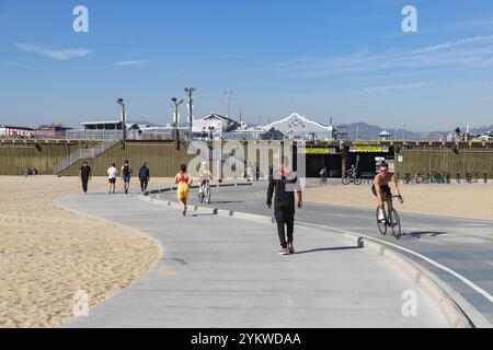 Una foto dell'iconica passeggiata sul lungomare di Santa Monica Beach con persone che camminano su di essa Foto Stock