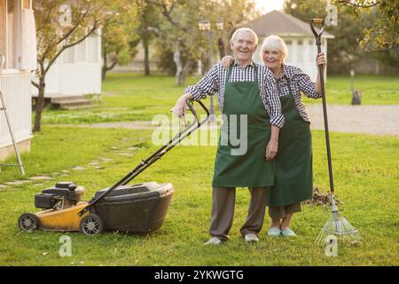 Un paio sorridente di giardinieri anziani. Gente felice all'aperto, estate. Lavori di manutenzione del giardino Foto Stock