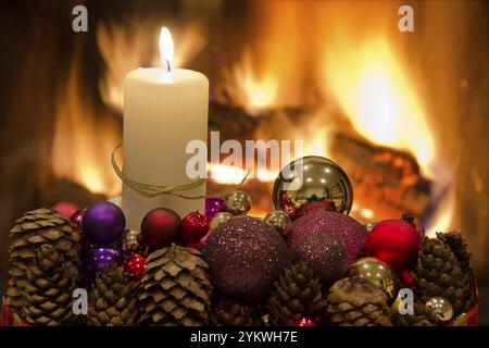 Decorazioni floreali natalizie con tavoli di fronte al caminetto e candele Foto Stock