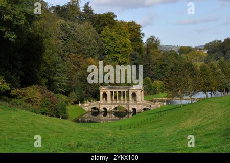 Il ponte palladiano, sotto il sole autunnale, sul lago nei giardini del Priory Park di Bath. Progettato nel XVIII secolo da Alexander Pope e landsca Foto Stock