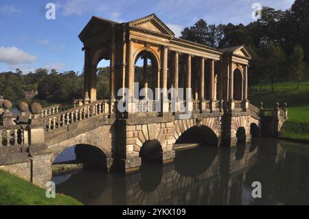 Il ponte palladiano, sotto il sole autunnale, sul lago nei giardini del Priory Park di Bath. Progettato nel XVIII secolo da Alexander Pope e landsca Foto Stock