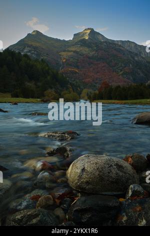 fotografia verticale con una lunga esposizione per segnare la differenza tra il flusso dell'acqua e la quiete delle rocce, primo piano di una roccia e. Foto Stock