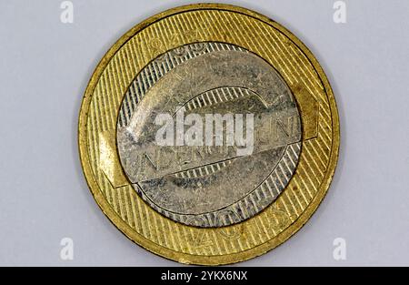 Primo piano di una moneta da un libbra indossata della metropolitana di Londra, che mostra l'anello esterno in oro, il cerchio interno in argento con il logo e il testo della metropolitana, e il Foto Stock