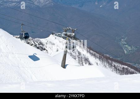 Funivie panoramiche su piste innevate in una regione montuosa durante la stagione invernale - Rosa Khutor, Russia, 15 aprile 2023. Foto Stock