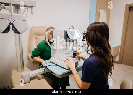 Optometrista che conduce un test oculistico con attrezzature avanzate in un ambiente clinico moderno Foto Stock