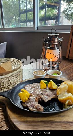 Manzo arrosto accompagnato da peperoni e patate al forno con tortillas, fagioli e limoni in stile messicano Foto Stock