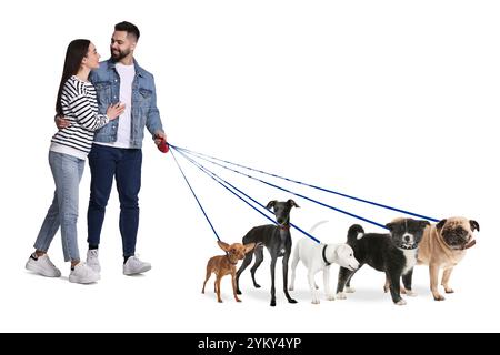 Giovane uomo e donna con cinque cani diversi su sfondo bianco. Servizio di passeggio per cani Foto Stock