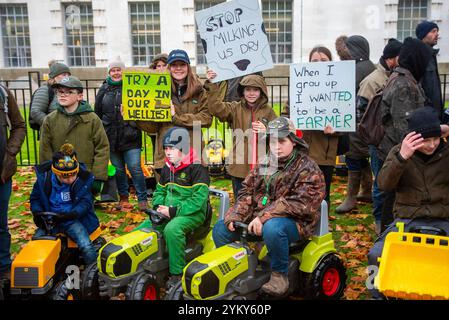 Londra, Regno Unito. 19 novembre 2024. I bambini tengono i cartelli e si siedono sui trattori giocattolo durante la manifestazione all'aperto presso Downing Street a Londra. Diecimila agricoltori e sostenitori hanno manifestato fuori a Downing Street a Londra in seguito alla controversa tassa di successione che è stata recentemente introdotta il giorno del bilancio dal governo laburista. Credito: SOPA Images Limited/Alamy Live News Foto Stock