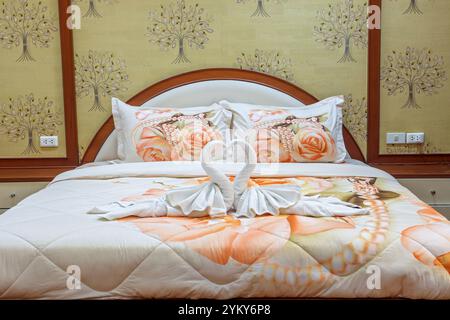 Letto decorato con cigni da asciugamani in una camera d'albergo Foto Stock