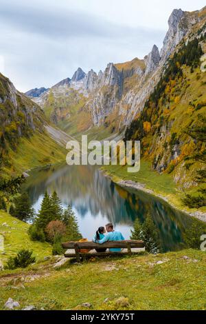 Una coppia si siede a stretto contatto su una panchina, circondata dal paesaggio mozzafiato del lago Falensee. Foto Stock