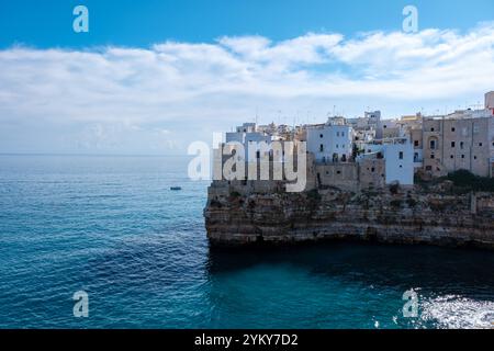 Polignano a Mare si adagia dolcemente contro le aspre scogliere della Puglia, rivelando pittoreschi edifici imbiancati che si affacciano sul tranquillo Mediterraneo Foto Stock