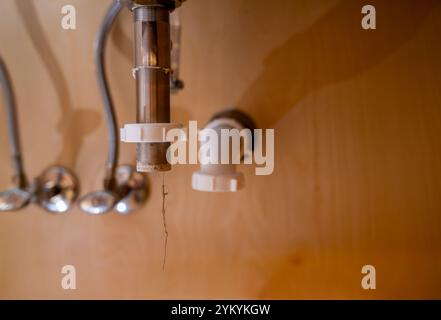 attenzione selettiva a uno scarico del lavandino del bagno scollegato con un'ostruzione dei capelli appesa Foto Stock