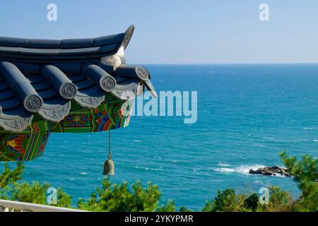 Contea di Yangyang, Corea del Sud - 3 novembre 2024: L'angolo ornato di un tradizionale tetto coreano con una campana decorativa è appeso sopra Foto Stock