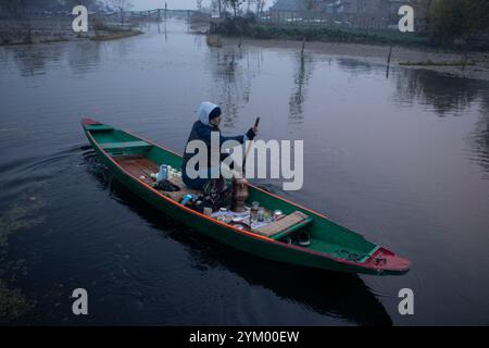 Srinagar, Jammu e Kashmir, India. 20 novembre 2024. Un uomo vende la famosa "Kahwa" calda del Kashmir in un mercato galleggiante nel profondo del lago dal in una fredda mattinata invernale a Srinagar. Il Kahwa è un tè popolare in Kashmir, Asia centrale, Iran, Medio Oriente e Afghanistan. È fatto da foglie di tè verde bollenti con spezie aromatiche come cardamomo, cannella, chiodi di garofano e zafferano Kashmiri, addolcito con miele. (Immagine di credito: © Adil Abass/ZUMA Press Wire) SOLO PER USO EDITORIALE! Non per USO commerciale! Foto Stock