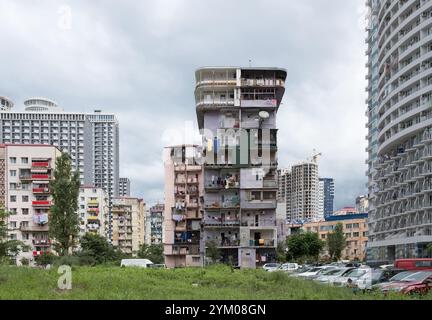 La facciata dei vecchi condomini multipiano a Batumi, Georgia. Vestiti appesi su un ramo sui balconi. Foto Stock