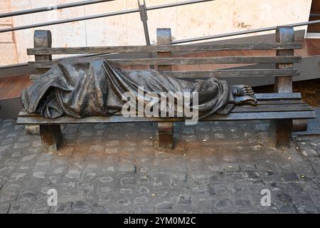 Roma, Italia - 31 ottobre 2024: Senzatetto Gesù la scultura in bronzo di Timothy Schmalz raffigurante Gesù come senzatetto, che dorme su una panchina del parco Foto Stock